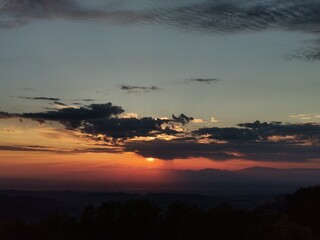 A breathtaking sunset with vibrant orange, pink, and purple hues illuminating the sky over a calm...