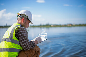 A specialist engineer at a treatment pond is checking the water quality of the treated pond.