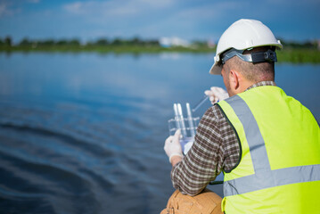 An inspector is inspecting water released by an industrial plant into a community public river.