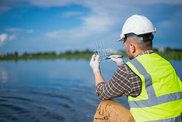 An inspector is inspecting water released by an industrial plant into a community public river.