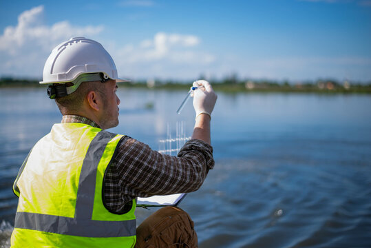 A specialist engineer at a treatment pond is checking the water quality of the treated pond.