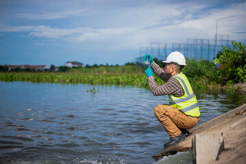 An environmental expert is collecting water samples from a treatment pond to be taken back to the...