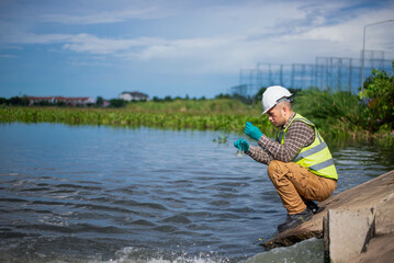 An environmental expert is collecting water samples from a treatment pond to be taken back to the...