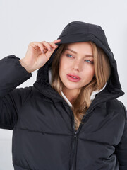 Fashionable woman model poses in stylish black puffer jacket indoors