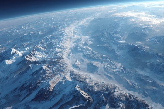 Breathtaking overhead view featuring expansive snow-covered mountains, pristine white glaciers, and faint horizon against deep blue sky