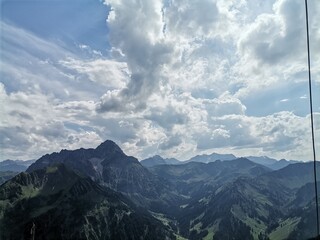 A collection of atmospheric mountain landscapes featuring dramatic cloud formations, drifting fog,...