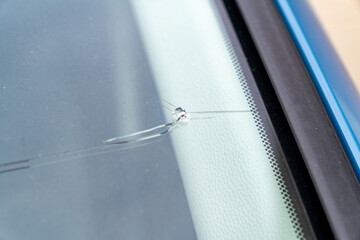 飛び石でヒビが入った車のフロントガラスの写真