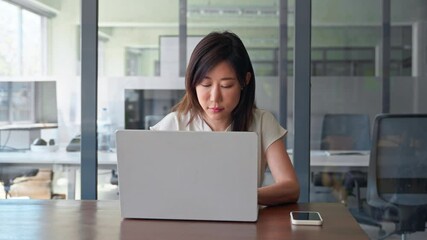 Busy mature Asian professional businesswoman analyst working concentrated on laptop pc at desk in office. Middle-aged woman using computer technology for financial marketing work online. Copy space - Powered by Adobe