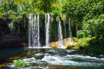 Antalya, Turkey: Upper Duden Waterfall cascade into river, surrounded by vibrant green trees. This famous Antalya waterfall is a peaceful and scenic natural attraction
