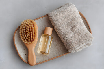 A natural hairbrush, oil bottle, and towel on a stylish tray create a serene self-care vibe