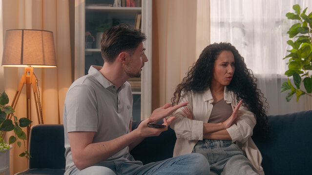 Upset angry couple arguing quarrel phone addicted jealous sms woman argument family problem Caucasian man guy male boyfriend husband argue offended Hispanic girl female girlfriend wife home conflict
