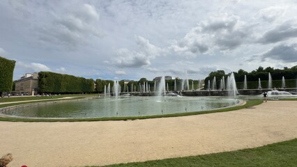 Oval Fountain with Water Jets, Hedges and Building Exterior