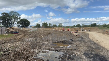 Construction Site with Dirt Piles, Wire Spools, and Machinery