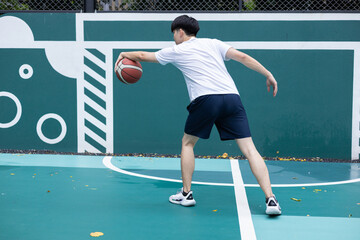 Young Man Playing Basketball on Outdoor Court