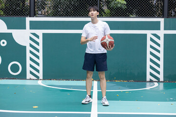 Young Man Playing Basketball on Outdoor Court