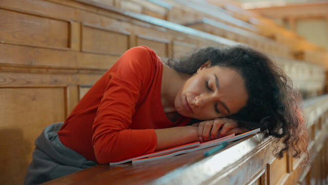 Sad boring tired exhausted Caucasian girl student Hispanic woman Latina lady American female sitting in university college auditorium bored lesson lecture study overworked falling asleep sleep napping