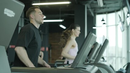 Man and woman doing fitness exercises in gym. Strength, endurance and training focus in modern fitness center - Powered by Adobe