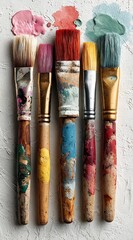 Fototapeta premium Colorful Paintbrushes Resting on a Textured Canvas Background Artistic Supplies for Painting