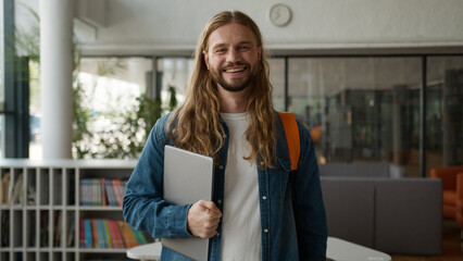 Caucasian student guy man male posing in university college academy hall corridor holding laptop...