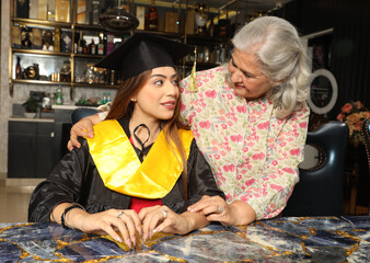 Indian Happy young girl holding certificate 
with her Grand Mother on graduation day