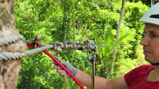 A man is enjoying an exhilarating ride on a zip line that traverses the thick woods surrounding him