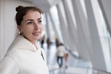 Smiling young woman looking while standing near the panoramic window