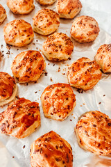 Freshly baked pastry rolls with sesame seeds displayed on parchment paper