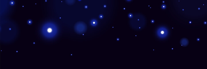 Blue glowing particles on dark background with soft bokeh light effect and dreamy cosmic atmosphere