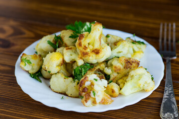 Fried cauliflower with spices and herbs in a frying pan