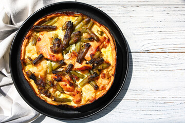 Delicious vegetable quiche served on a black plate in a bright kitchen setting