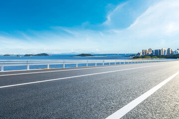 Empty asphalt coastal road with city skyline with blue sea in Zhuhai, China.