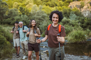 Smiling woman leads her family at hike adventure with family
