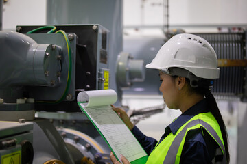 Substation engineer inspects gas insulated switchgear equipment carefully wearing safety helmet and...