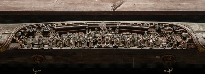 Detailed wood carving shows figures in procession including musicians, officials, and attendants in...