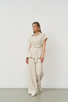 Fashionable woman posing indoors in chic beige outfit with stylish flair