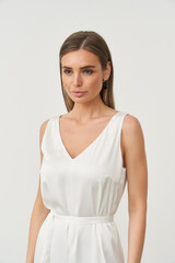 Stylish woman posing elegantly in a fashion studio with a minimalist backdrop