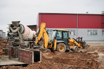 Construction equipment working hard at an industrial site under overcast skies