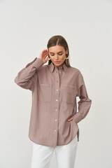 Fashionable female model showcasing stylish indoor clothing in a studio setting