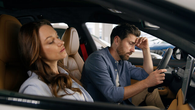 Caucasian couple sitting inside automobile angry mad woman female wife arguing talking argument bully sad man male husband close ears ignoring protecting family problem conflict in car auto driving