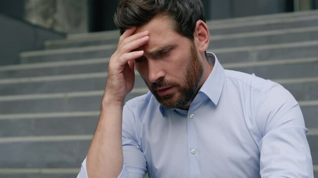 Stressed fired business man upset frustrated grief businessman upset in city middle-aged male entrepreneur suffering holding head headache financial crisis sad thinking close face with hands migraine - Powered by Adobe
