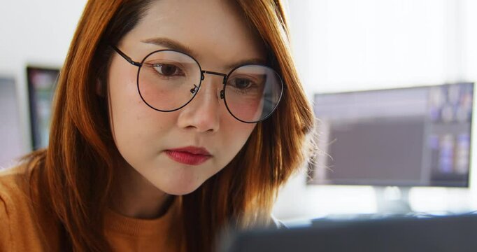 Asian female freelance programming developer work alone using desktop and laptop computer at home office. Information technology, smart woman, software engineer programmer coding job. Close up