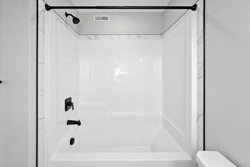 White bathroom with a black shower head and a white bathtub
