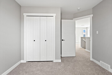 White bedroom with a white closet and a white door