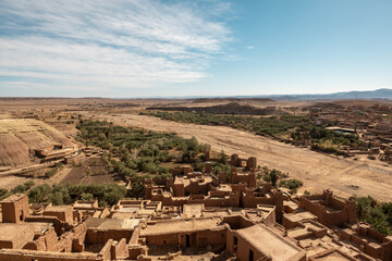 Aerial view of the historic fortified village of Aït Benhaddou in Morocco, featuring traditional mudbrick architecture against a vast desert landscape.