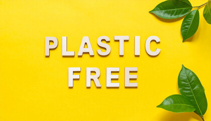 PLASTIC FREE text on yellow surface. Eco-friendly message promoting sustainability. Close-up.