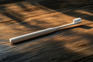Modern electric toothbrush resting on a rustic wooden table, illuminated by warm sunlight