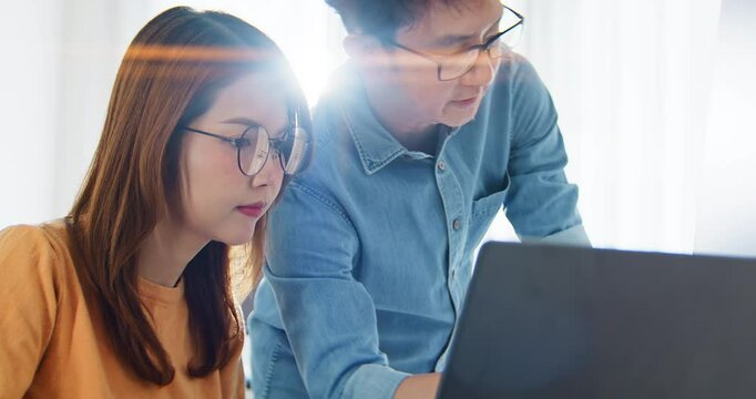 Asian male, female programming developer work together at home office, brainstorm discussion. Information technology, software engineer programmer coding job, man and woman coworker teamwork concept