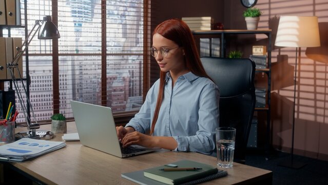 Business female woman businesswoman typing laptop in office smiling girl lady worker in company looking at camera positive working computer pc internet startup job online marketing management work
