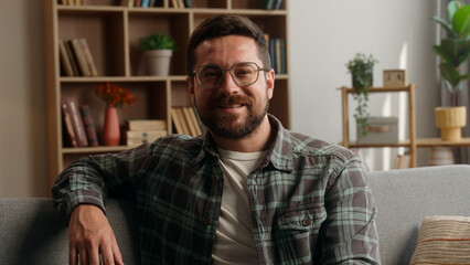 Portrait happy smiling carefree positive headshot Caucasian man male bearded guy in glasses health homeowner in own apartment smile looking at camera relaxing at home loan mortgage insurance satisfied