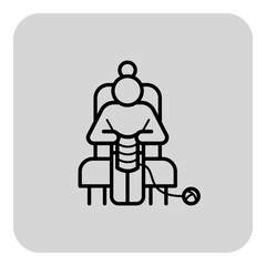 Senior woman comfortably seated in chair, focused on knitting. Hobby and retirement concept